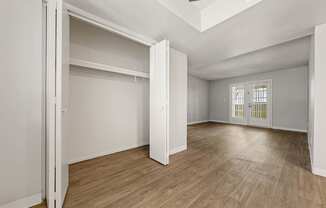 a bedroom with hardwood floors and white walls