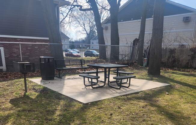 a picnic table in a park next to a fence