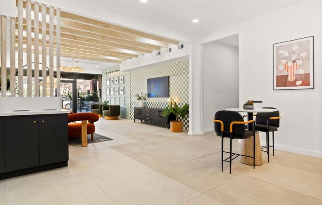 A modern kitchen with black cabinets and a wooden slatted wall.