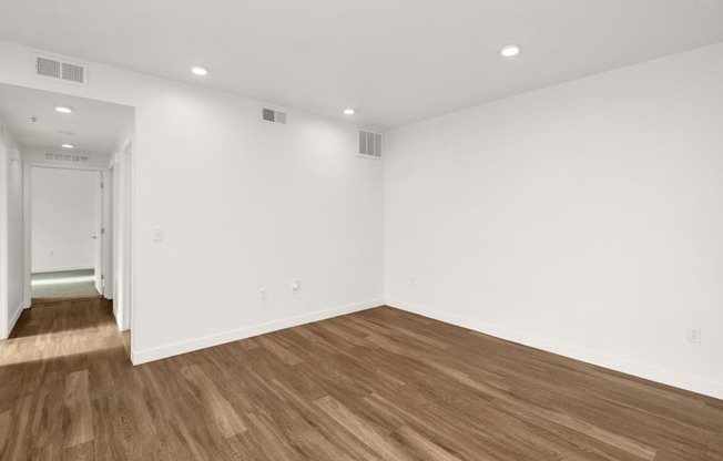 a living room with white walls and wood floors