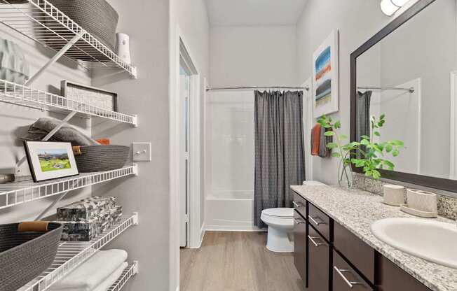 A bathroom with a white toilet, a sink, and a mirror.
