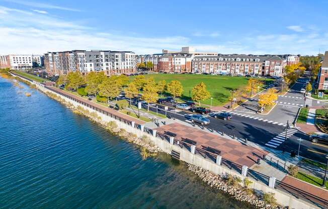 A view of a waterfront with a road and apartment buildings.