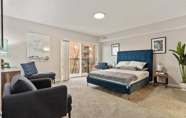 A bedroom with a large bed and a chair.