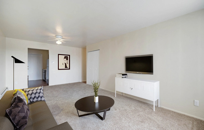 Living room at Sunridge Apartment Homes in Englewood, CO, with modern finishes and wall-mounted TV setup.