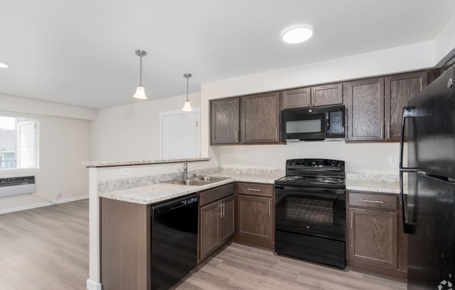 a kitchen with dark wood cabinets and black appliances