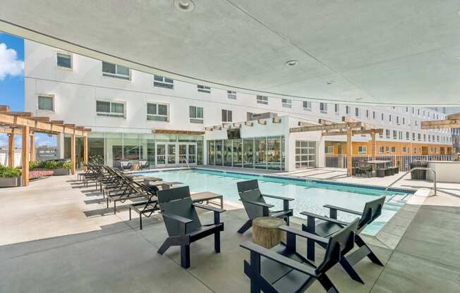 swimming pool with sun deck and covered lounging areas at One Santa Fe apartments