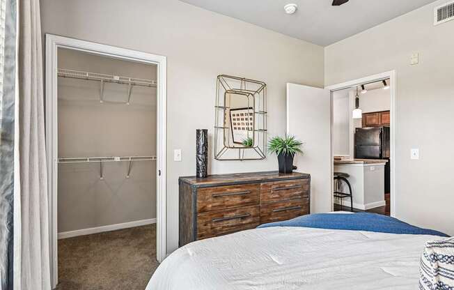A bedroom with a bed, a dresser, and a closet.