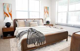 A bedroom with a bed covered in a black and white checkered blanket.