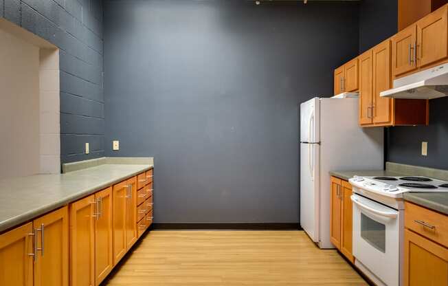 an empty kitchen with wooden cabinets and a white refrigerator