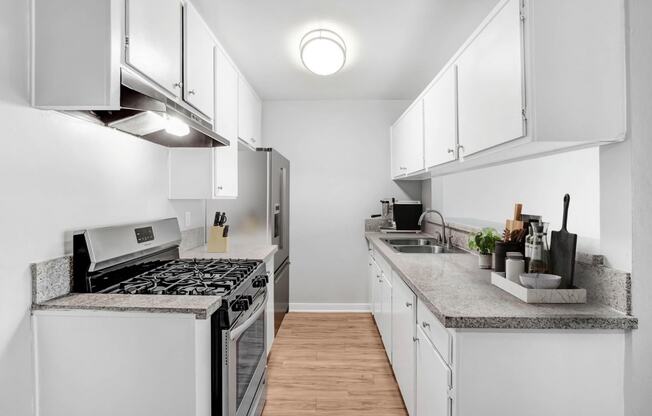 a renovated kitchen with white cabinets and stainless steel appliances