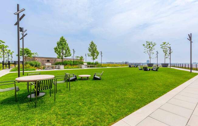 A park with a grassy area, a picnic table, and a walkway at Allied Harbor Point, Baltimore