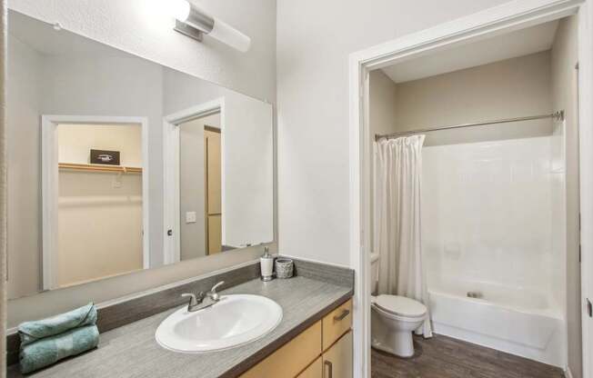 A bathroom with a white sink and a white toilet.