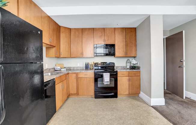 a kitchen with black appliances and wooden cabinets