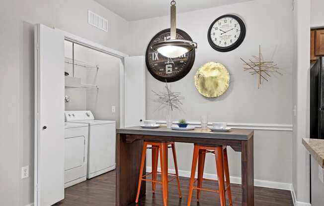 a kitchen with a table and stools and a refrigerator