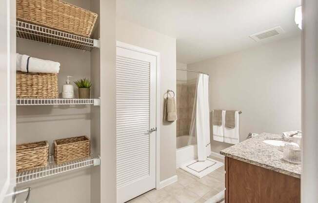 A bathroom with a white door, a white sink, and a white counter.