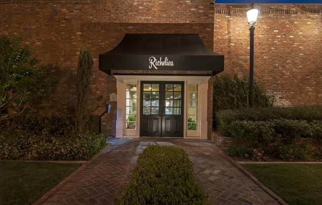 a resident advising office at night with a black awning and a brick path to the