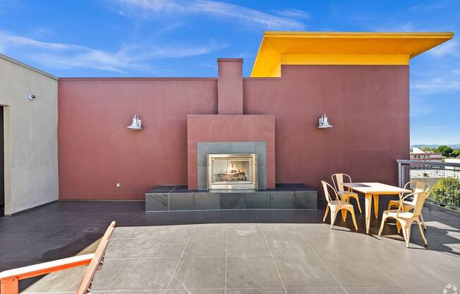 A patio with a fireplace and chairs.