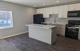 a kitchen with an island and a stove and a window