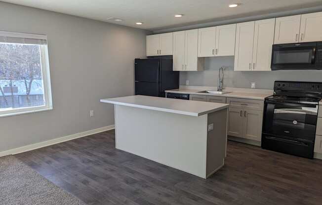 a kitchen with an island and a stove and a window