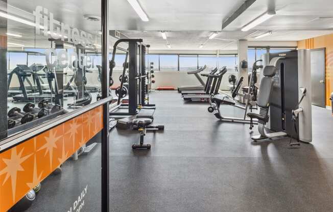 a gym with cardio machines and weights on the floor