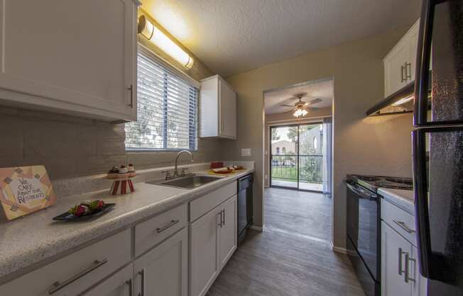 a kitchen with white cabinets and a sink and a doorway