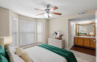 a bedroom with a large bed and a ceiling fan