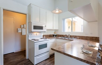 a kitchen with white appliances and a counter top