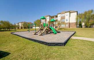 A playground with a green slide and a green canopy.