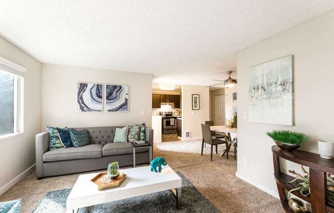 A living room with a grey couch and a white coffee table.