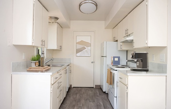 A kitchen with white cabinets and appliances.