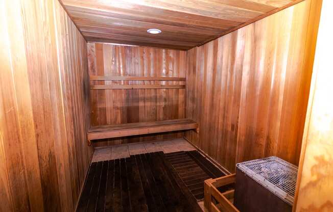 a wooden sauna with a bench and shelves