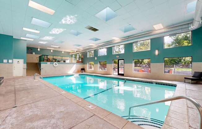 A large indoor swimming pool with a glass enclosure.