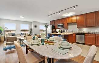A modern kitchen with a dining table set for two.