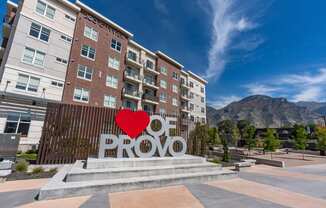 a large red love heart sculpture in front of a building with the word roo