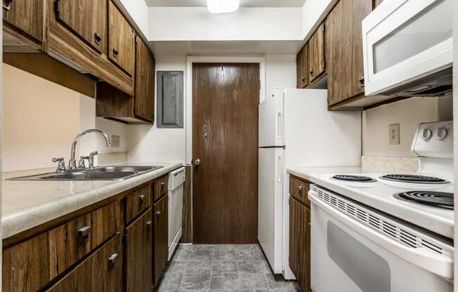 a kitchen with white appliances and wooden cabinets and a refrigerator