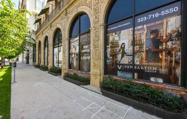 A sidewalk in front of a building with a large window advertising the Van Barton Group.