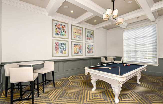 a games room with a pool table and chairs