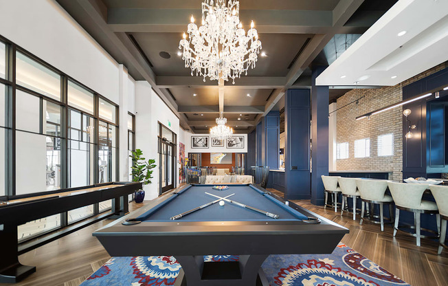 a chandelier hangs over a pool table in a game room at Altis Grand Central, Florida, 33606