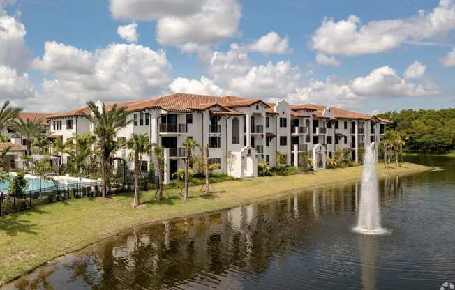 a large pond with a fountain in front of a building