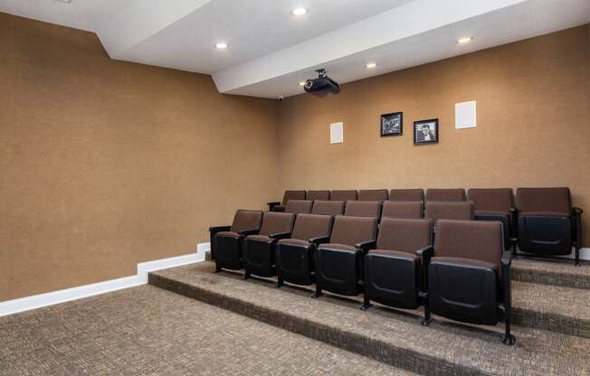 Theater room with projector and movie theater chairs at Adrian on Riverside in Macon, GA