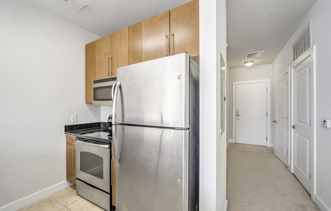 A kitchen with a stainless steel refrigerator and microwave.