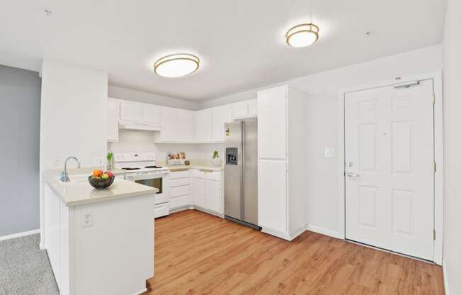 a kitchen with white cabinetry and a wooden floor