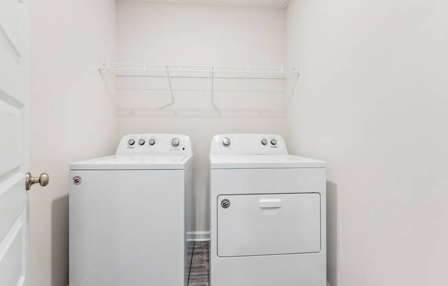 an empty laundry room with two washes and a dryer