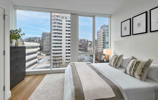 A bedroom with a large bed and a view of the city.