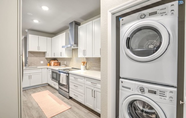 a white kitchen with a washing machine and a washer and dryer