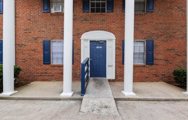 the front of a brick building with a blue door