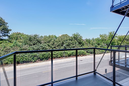 a balcony with a view of a street and trees