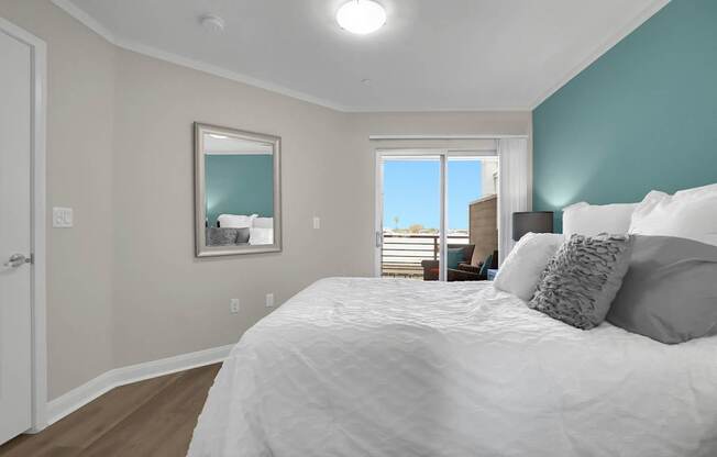 A bedroom with a large bed and a view of the outside through the window.