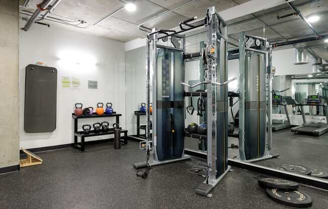 a fitness room with cardio equipment and weights