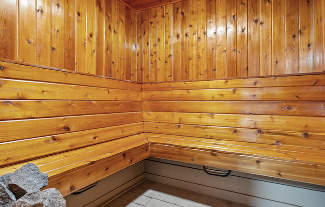 A wooden sauna with a bench at apartment complex